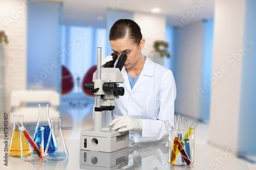 Microbiologist examining biological samples with a microscope in the laboratory.