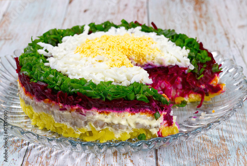herring salad under a fur coat on the nice plate. close up