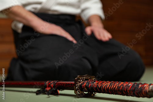 Fotografija Close up of young martial arts fighter with katana siting in seiza position