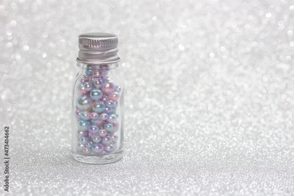 Bottle full of pearls on glitter background Bottle full of pearls on glitter background