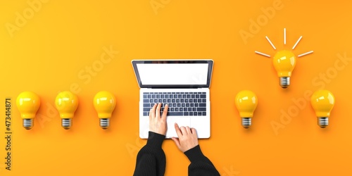 Person using a laptop computer with light bulbs from above