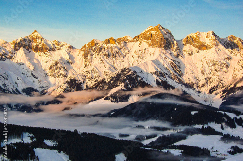 Sunrise in Maria Alm, Hinterthal in Austria. Winter landscape, stunning mountain range, snowy trees and blue sky