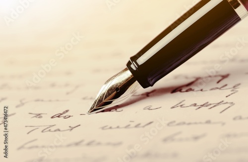 Fountain pen on an antique handwritten letter. Vintage pen and handwritten cursive style