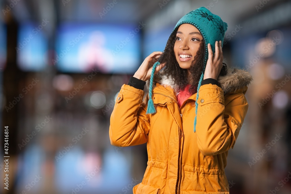 Portrait of happy woman wearing warm hat on city street and looking at camera. Portrait of happy woman wearing warm hat on city street and looking at camera.