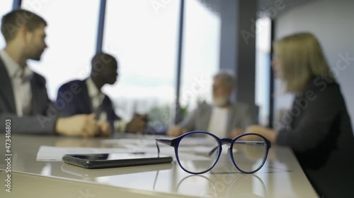 colleagues meeting to discuss their future financial plans seen by unfocused glasses photo