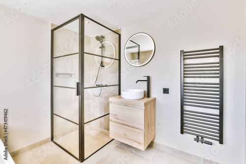 Delightful minimalist bathroom with illuminated round mirror