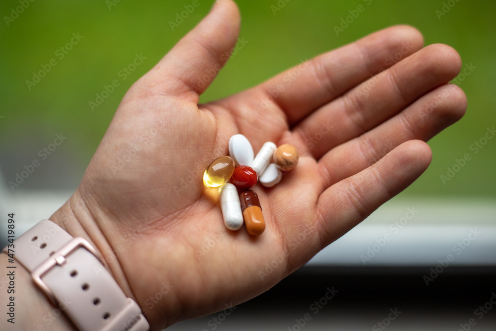 a handful of pills and capsules in the palm of your hand. a handful of pills and capsules in the palm of your hand.