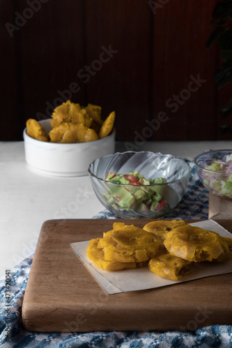 Patacones and Guacamole, vegan snack. Black background. Copy space.