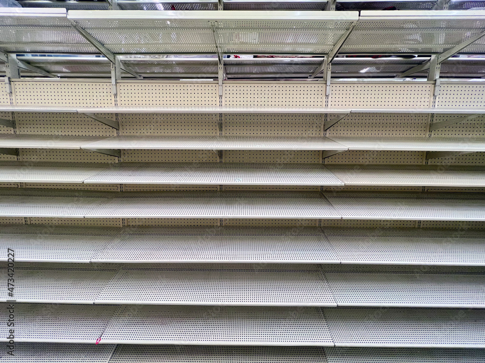 Empty shelves in a large big box department store. Stocking merchandise was problematic during the COVID-19 Coronavirus pandemic of 2021. Empty shelves in a large big box department store. Stocking merchandise was problematic during the COVID-19 Coronavirus pandemic of 2021.