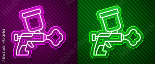 Glowing neon line Paint spray gun icon isolated on purple and green background. Vector