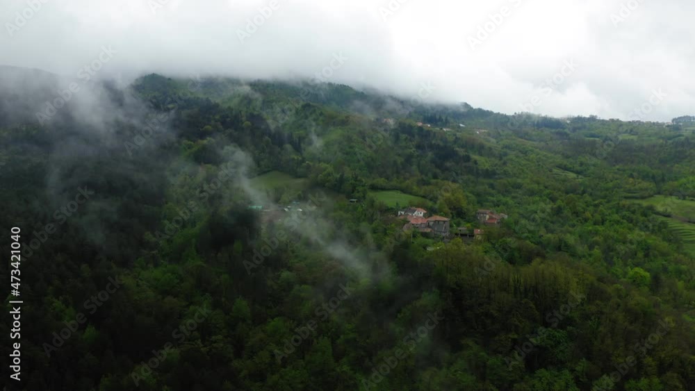 Aerial Forward Beautiful Shot Of Houses Amidst Green Trees On Hills Against Cloudy Sky - Apennine Mountains, Italy Aerial Forward Beautiful Shot Of Houses Amidst Green Trees On Hills Against Cloudy Sky - Apennine Mountains, Italy