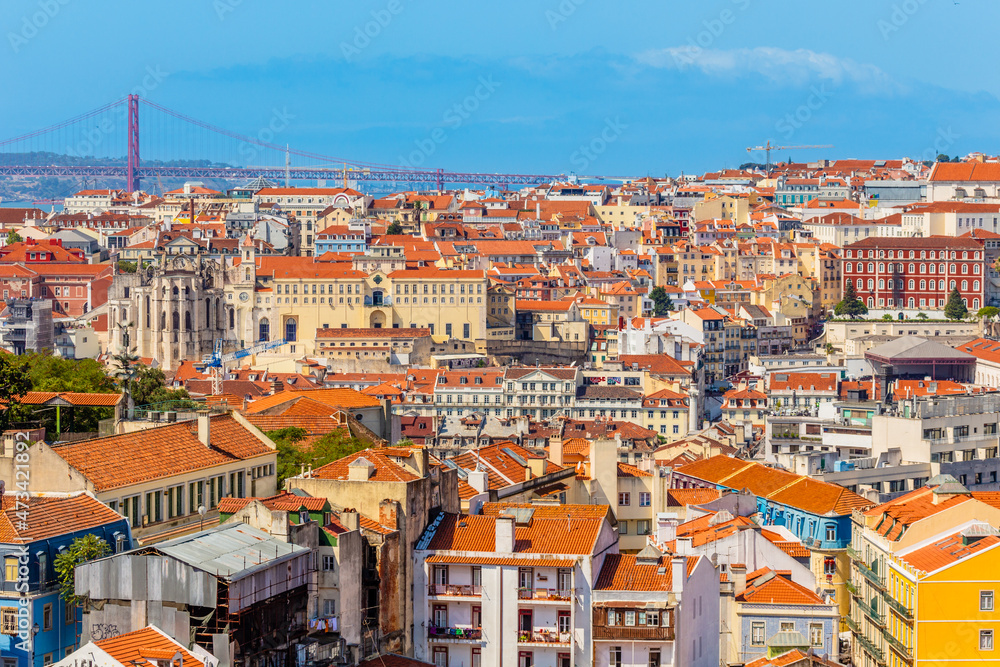 View to downtown of Lisbon with miltiple colorful houses and bridge of 25 of April over Tagys river, Portugal