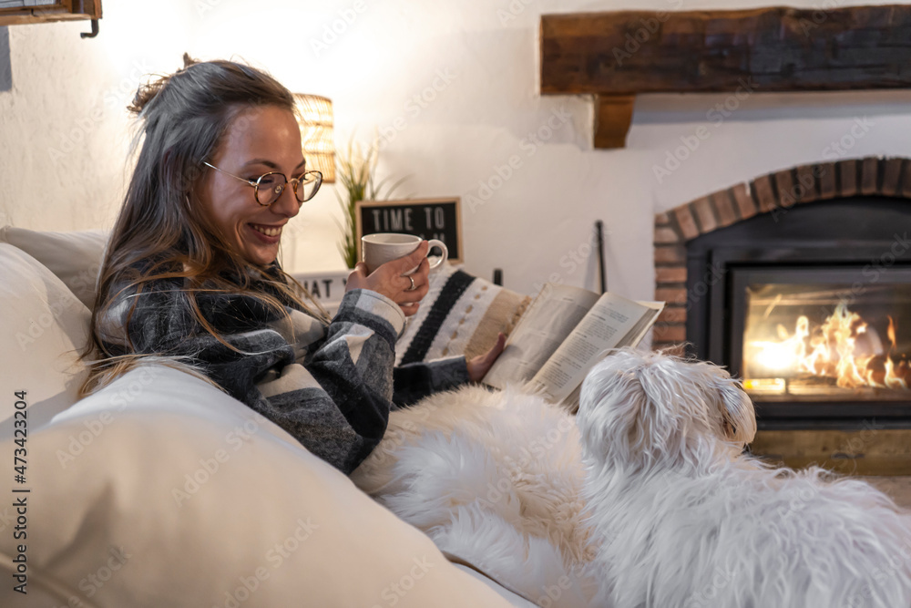 happy woman At Home Lying On Reading Book And Drinking Coffee with her dog happy woman At Home Lying On Reading Book And Drinking Coffee with her dog