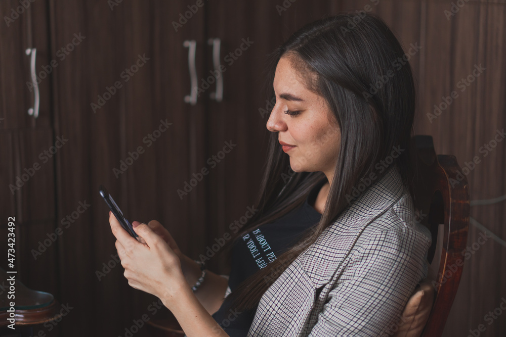 Young woman checking and typing on her cell phone. Young woman checking and typing on her cell phone.