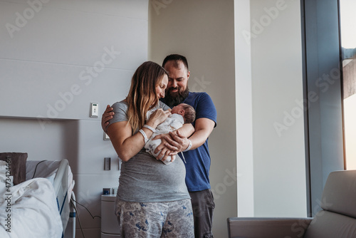 Newborn baby boy being cradled by new parents in birthing center