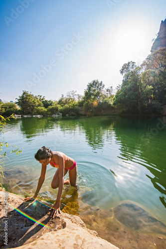 young woman climbing out of the Tha Falang river in Laos photo