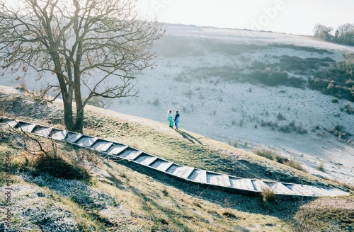 two kids stood on top of a big hill in the countryside in England photo