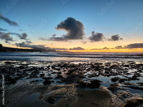 Pebble beach with reflects on the water with a amazing sunset in La Pared beach, Fuerteventura. photo