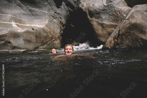 Friends Swimming Together with Boulders and Swirling Water around them photo