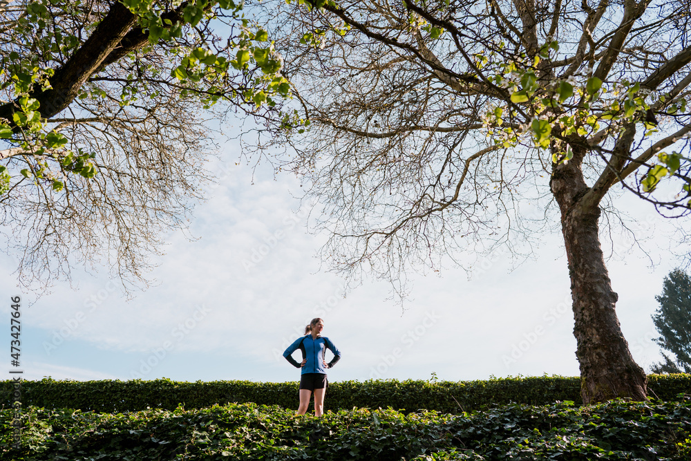 Young woman catches her breath and takes in the view while running Young woman catches her breath and takes in the view while running