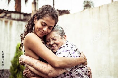Mexican women smile in loving hug embrace on summer street Mecxico photo