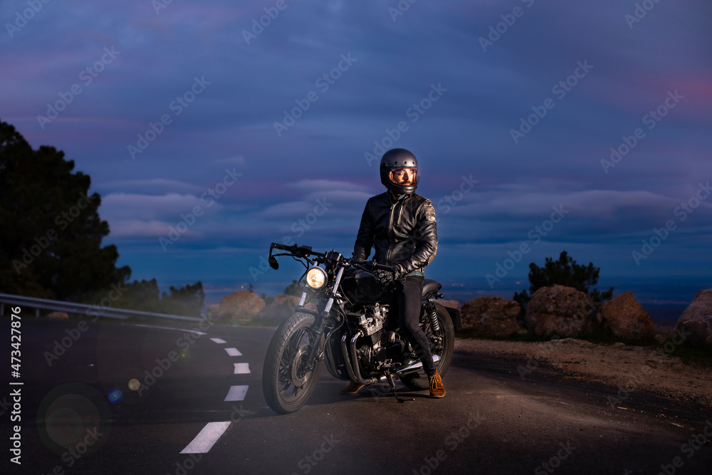 Motorcyclist on his choper motorcycle at night on the road Motorcyclist on his choper motorcycle at night on the road