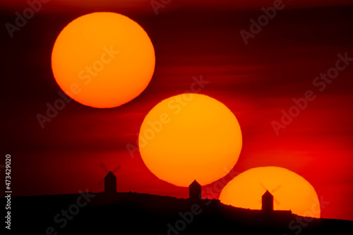 Sunset sequence silhouetting old windmills , Consuegra, Spain photo