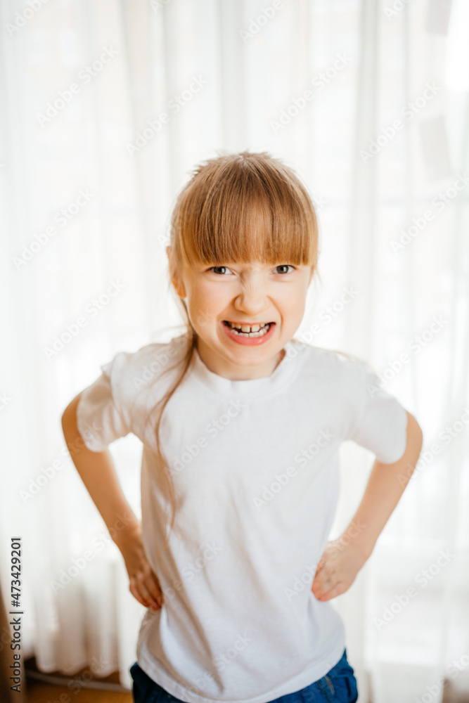 the girl shows her teeth and grimaces the girl shows her teeth and grimaces