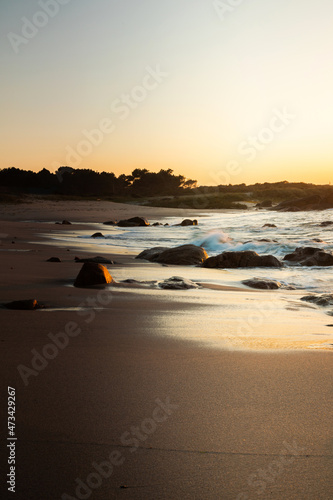 Sunset on a beach with rock formations on the Galician coast photo