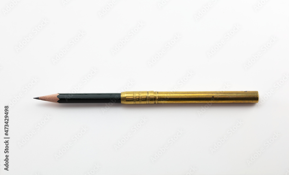 Extend, enlarge, increase, concept image, a short pencil in a brass pencil extender, isolated on neutral white. Extend, enlarge, increase, concept image, a short pencil in a brass pencil extender, isolated on neutral white.