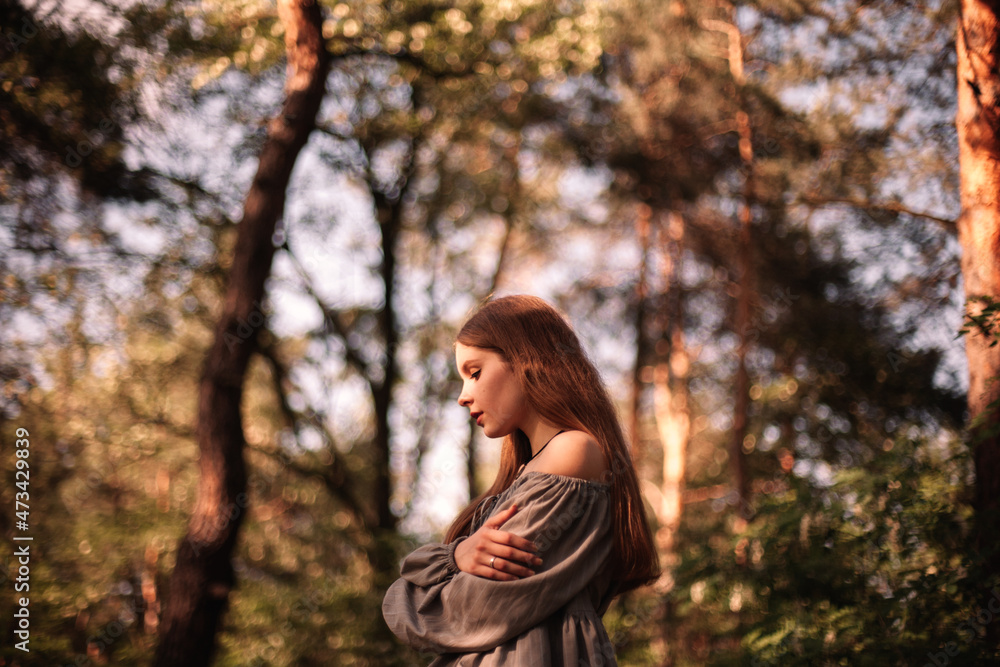 Side view of thoughtful teenage girl standing in forest during summer Side view of thoughtful teenage girl standing in forest during summer