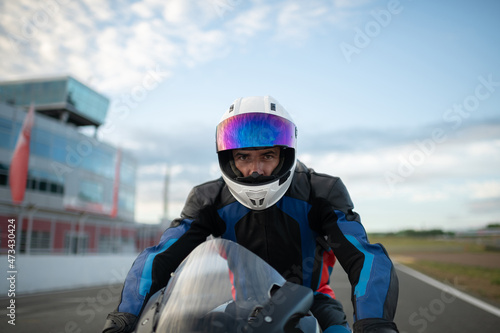 Motorcycle racer in helmet on track photo