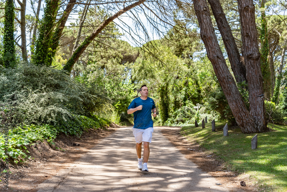 Front View of a man running outdoors training for Marathon Front View of a man running outdoors training for Marathon