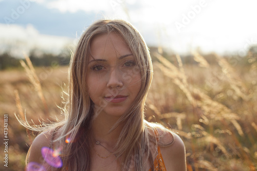 Headshot of a young woman standing in a hay field in the Virginia country side photo