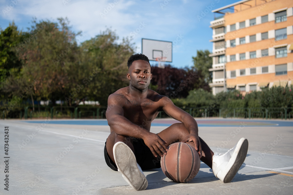 Black basketball player taking rest on street Black basketball player taking rest on street