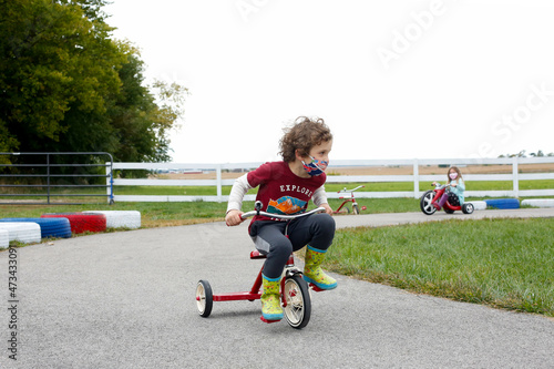Grade School Boy riding a tricycle at an apple orchard in the fall in Illinois photo