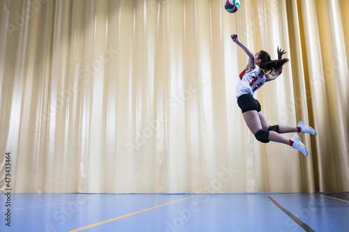 Professional female volleyball player in action serving ball photo
