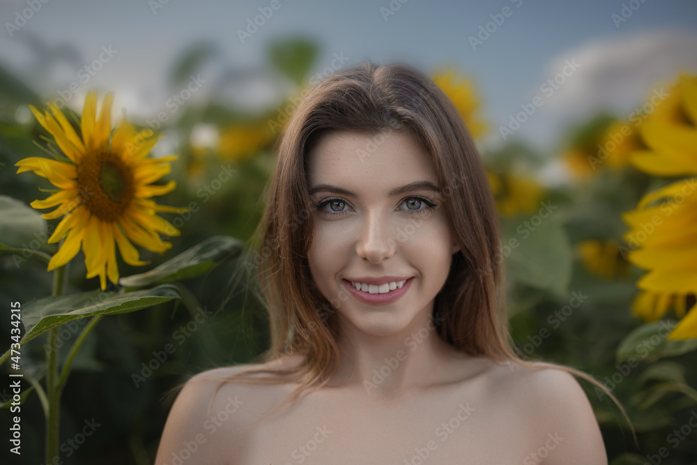 Beautiful smiling young woman on a field of sunflowers Beautiful smiling young woman on a field of sunflowers