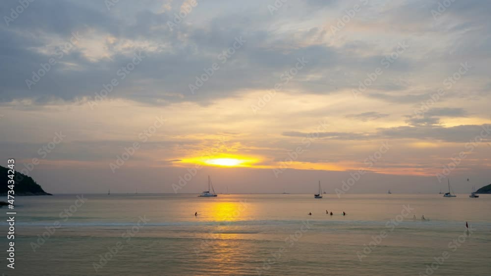 Timelapse Sail boat in tropical sea at beautiful sunset or sunrise sky with Reflected sun on water surface. Sunset over ocean Seascape in Phuket island Thailand Summer and travel vacation concept Timelapse Sail boat in tropical sea at beautiful sunset or sunrise sky with Reflected sun on water surface. Sunset over ocean Seascape in Phuket island Thailand Summer and travel vacation concept