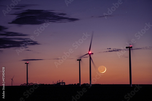 Cresecent Moon Sets Behind Wind Turbines photo