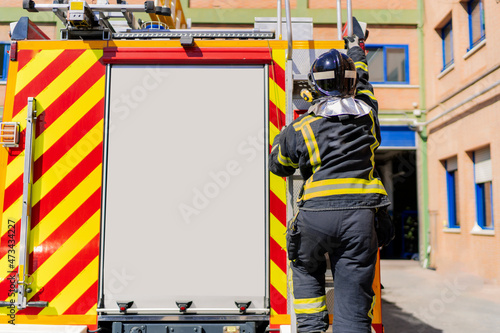 firefighter getting on the truck to work in emergency photo