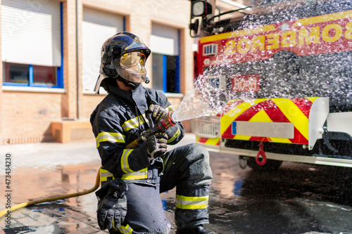 firefighter pouring water to extinguish a fire photo