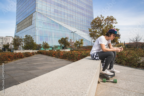 woman with cap sitting with skateboard photo