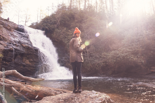 Girl Hiking in Front of Waterfall in Bright Sunlight