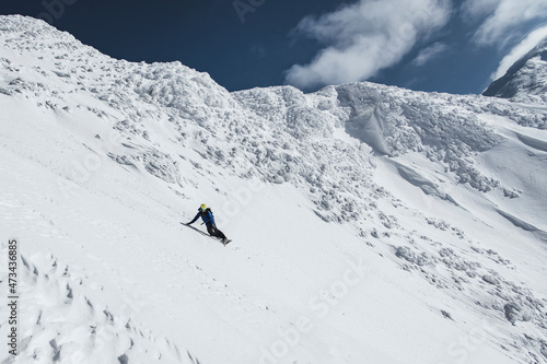 Man snowboarding on slope of snowcapped mountain during vacation photo