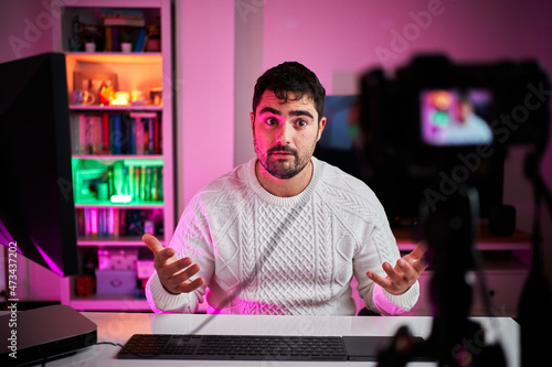 Young fat streamer on a room with multicolor lights