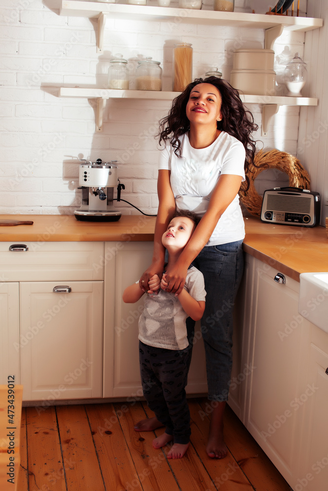 young pretty african american mother with little cute son on kitchen in morning preparing breakfast, lifestyle people concept young pretty african american mother with little cute son on kitchen in morning preparing breakfast, lifestyle people concept
