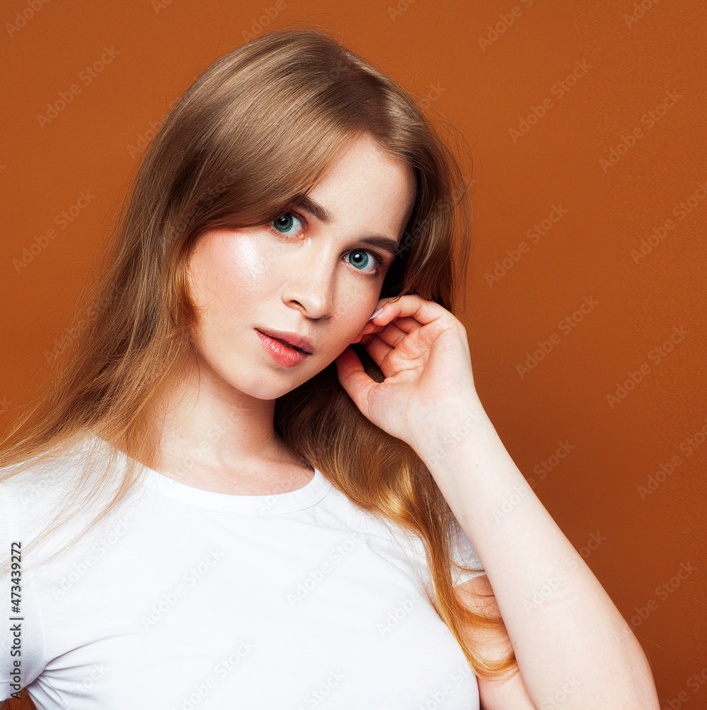 young pretty girl with blond hair posing cheerful on brown background, lifestyle people concept young pretty girl with blond hair posing cheerful on brown background, lifestyle people concept