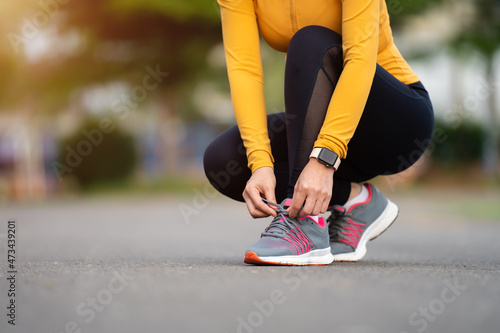 woman tying her running shoes in park