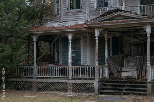 Obraz na plátne Abandoned dilapidated creepy wooden house clutter on front porch